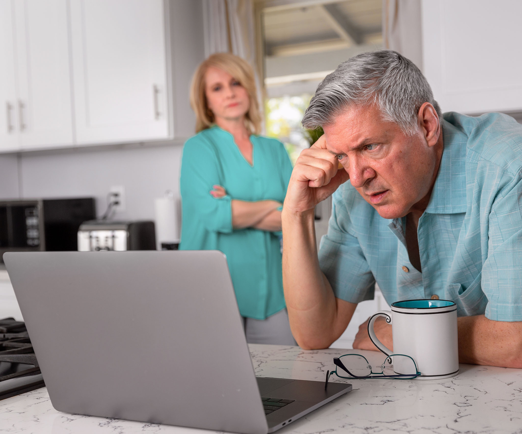 Senior man frustrated looking at laptop with woman