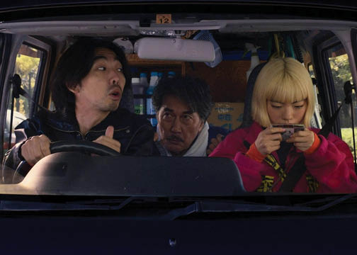 Still from film Perfect Days. Three Japanese people in a car, two men and a woman.