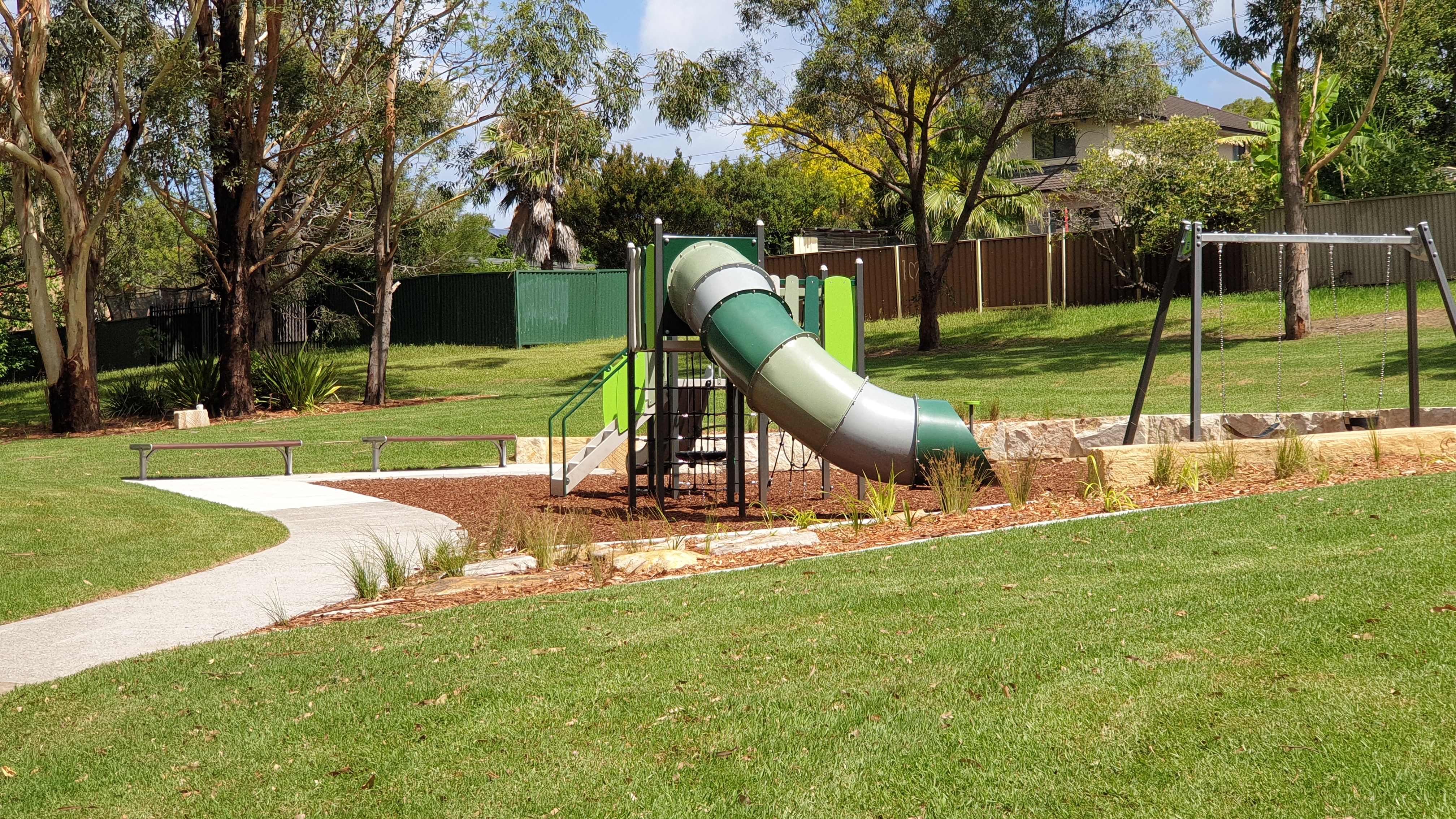 pathway leading to playground surrounded by green slope