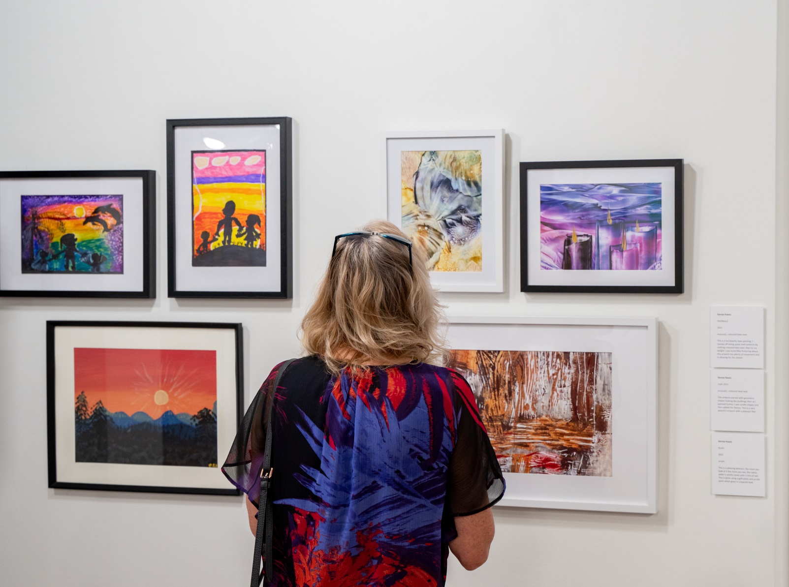 Person looking at art on a gallery wall at Hazelhurst Arts Centre