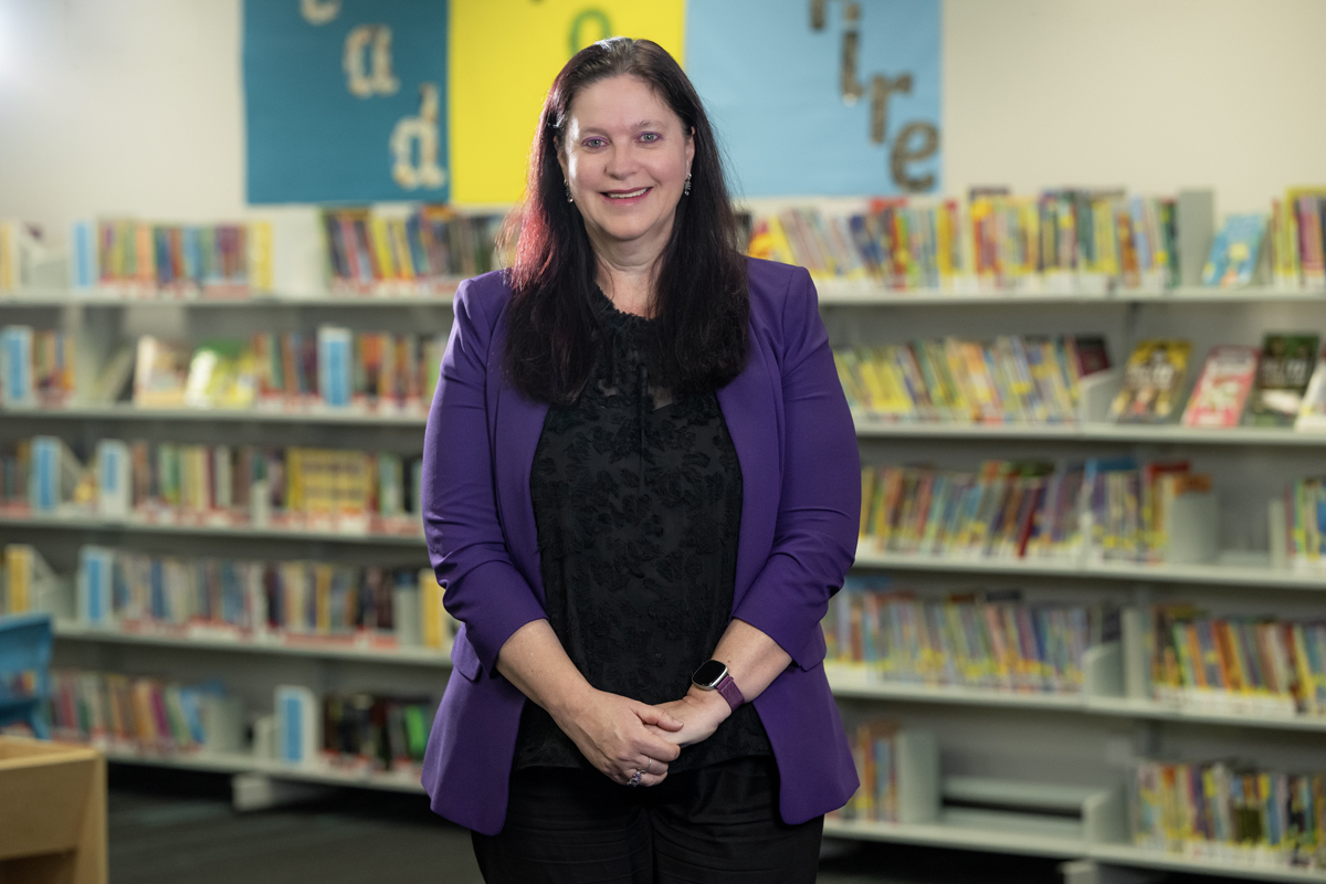 Woman standing in front of a book shelf.