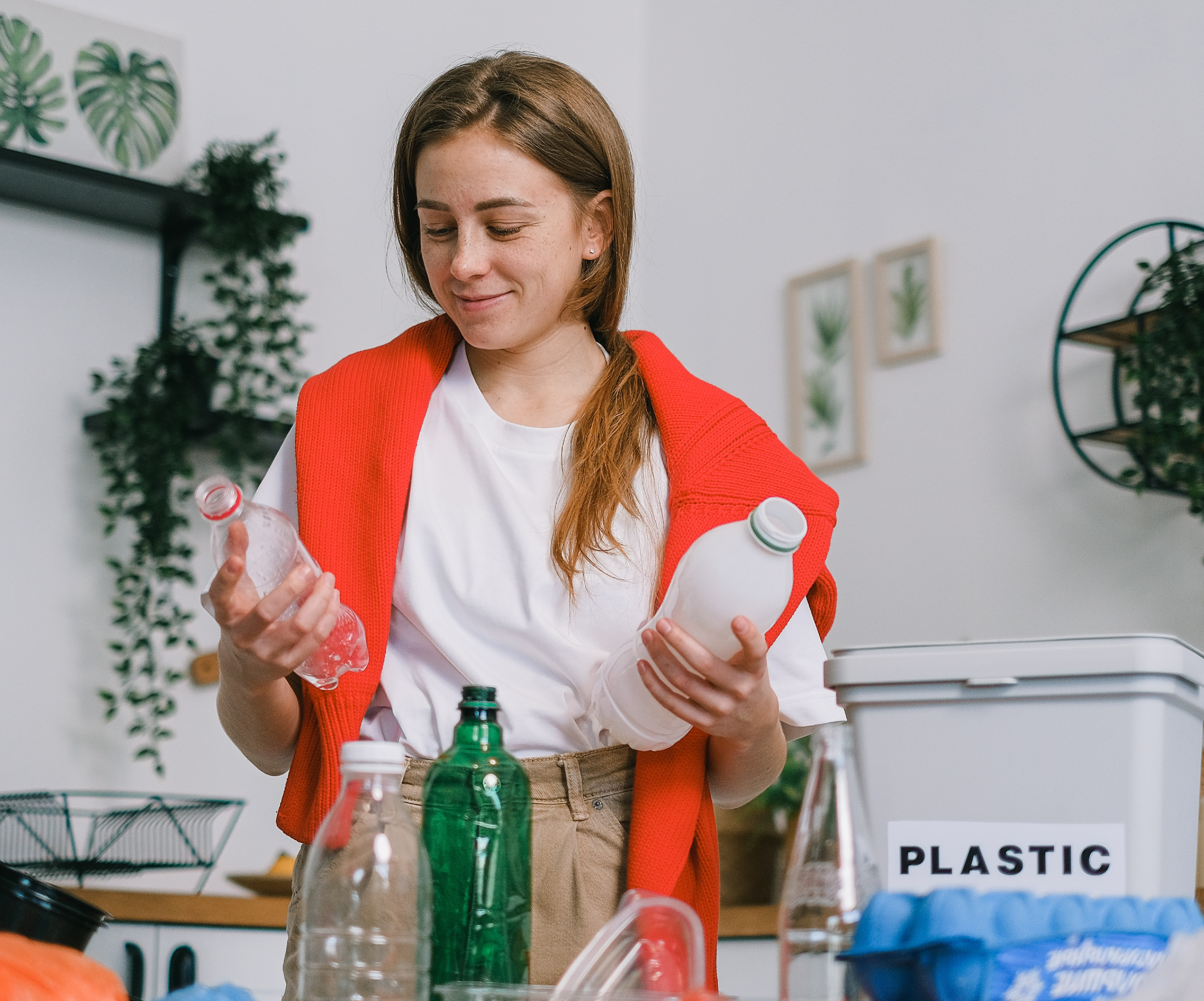 Woman recycling plastic in home kitchen