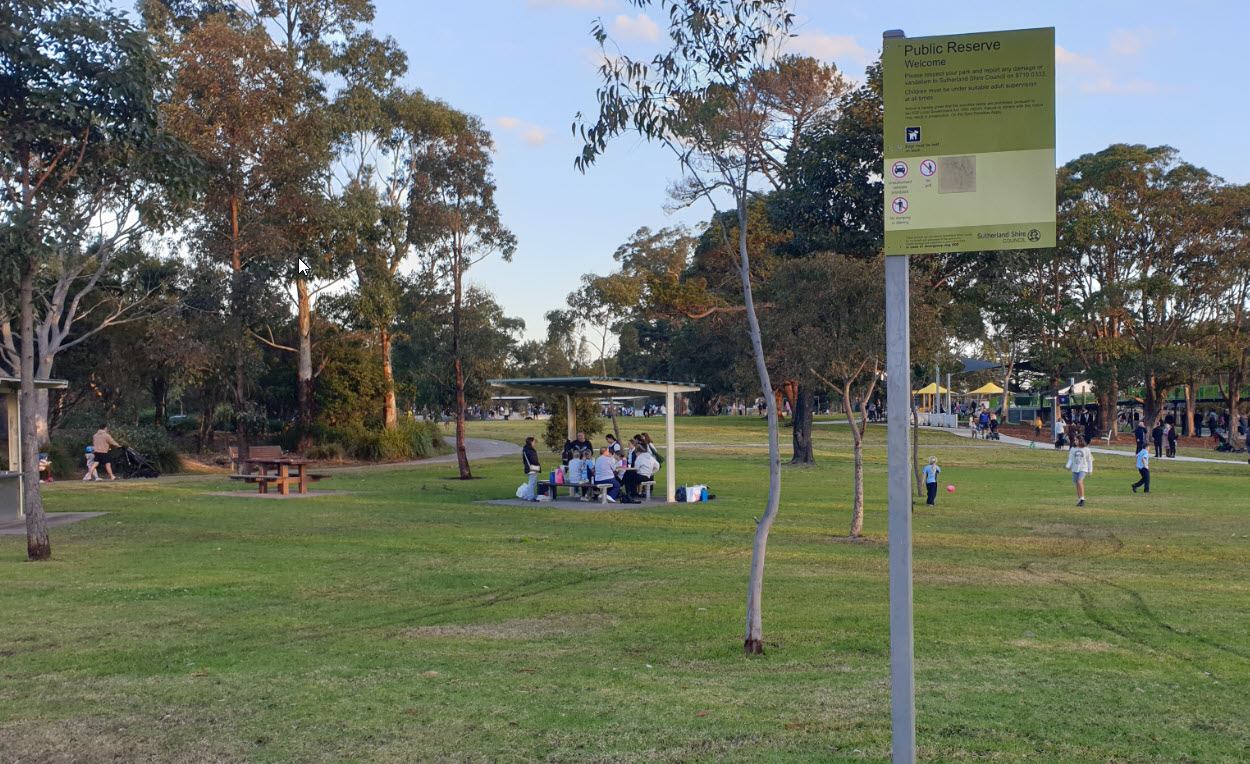 Open lawn with picnic table and park signage