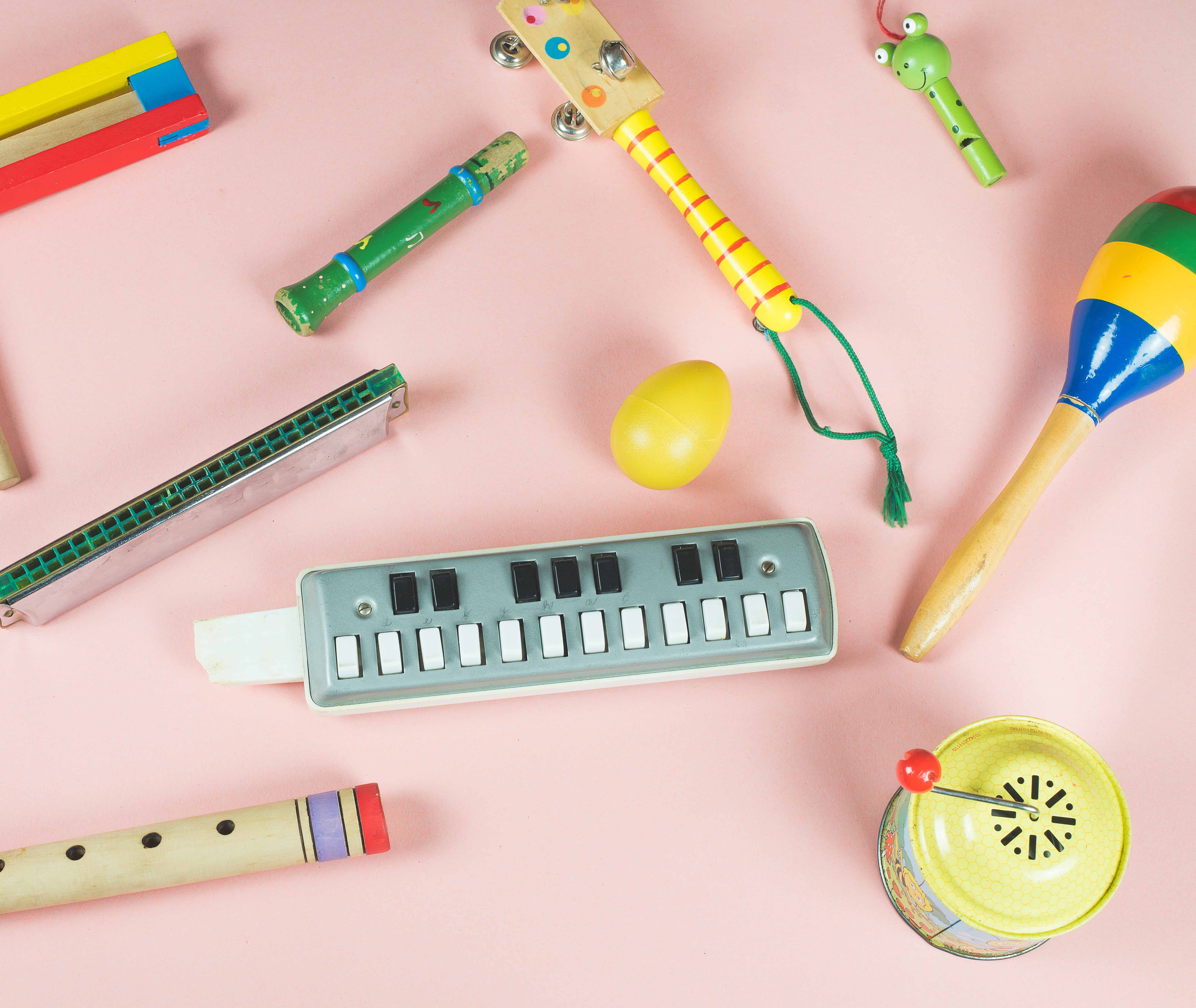 An assortment of musical instruments on a pastel pink background