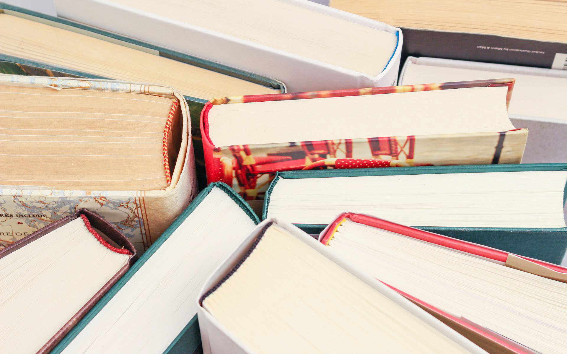 Books stacked cover to cover so edges of white pages are visible