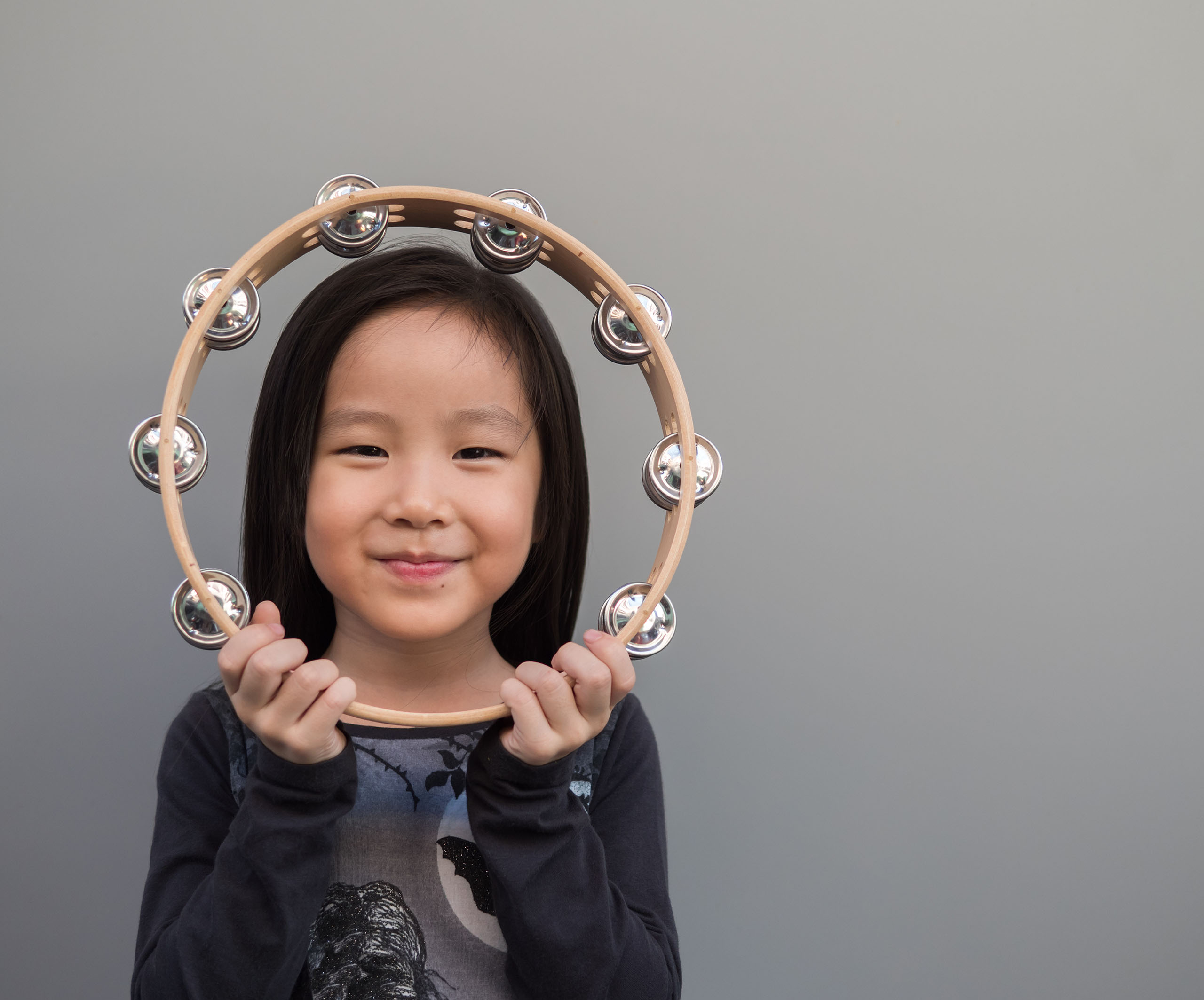 Young girl smiling holding tambourine