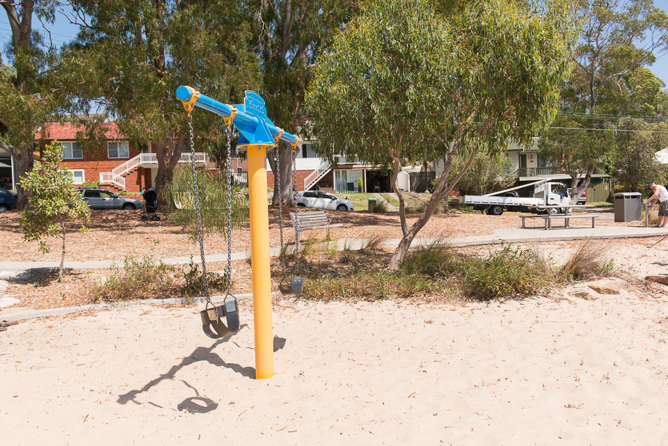 Double swing set in sandy playground