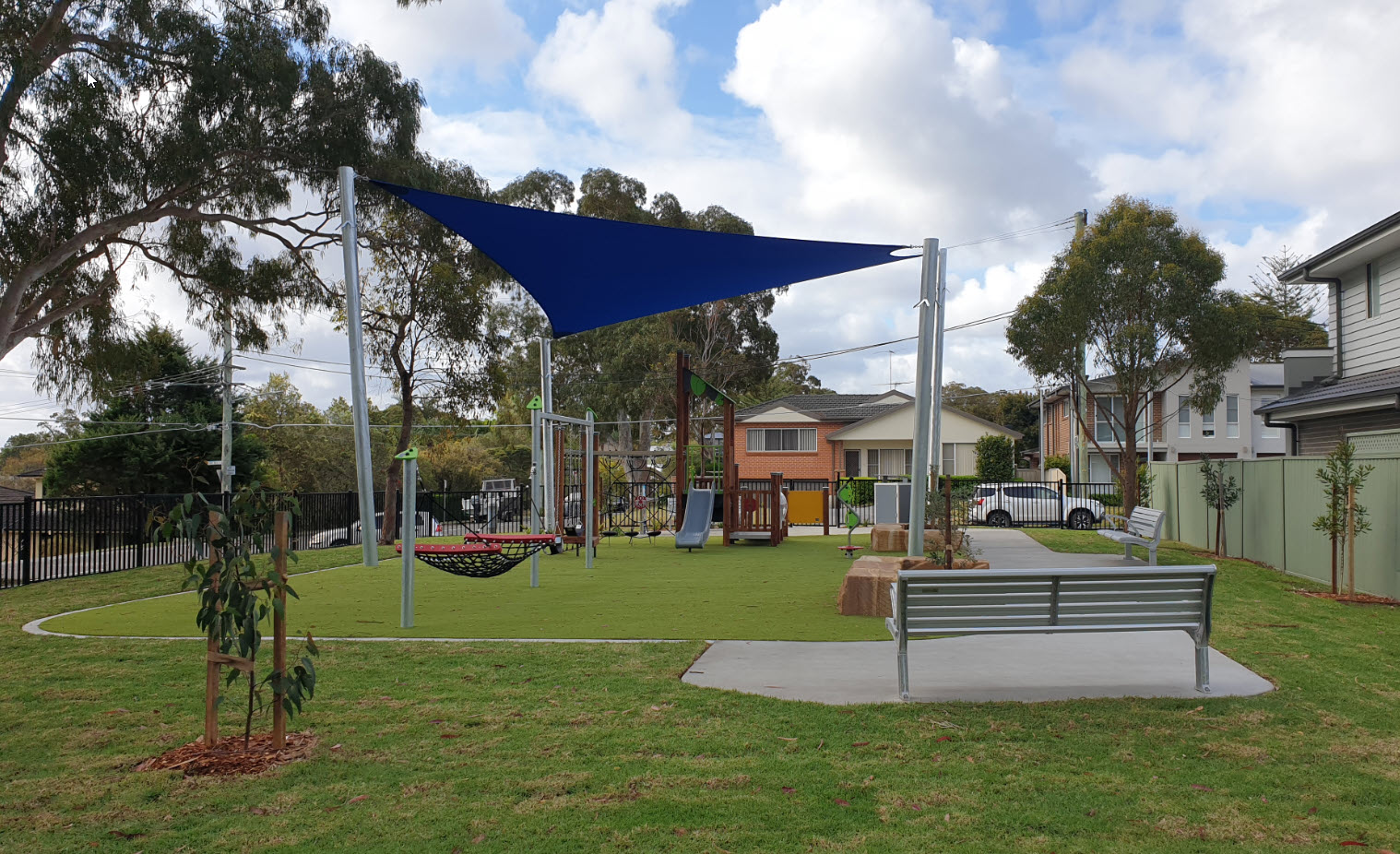 Open lawn with bench seating and play equipment