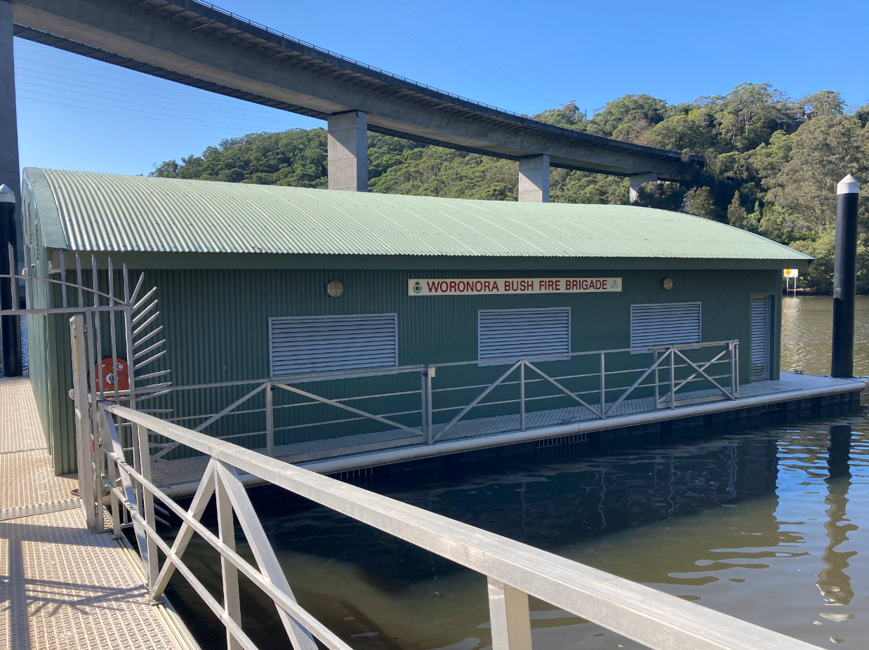 Large Green shed on floating pontoon under the high level road bridge over Woronora River