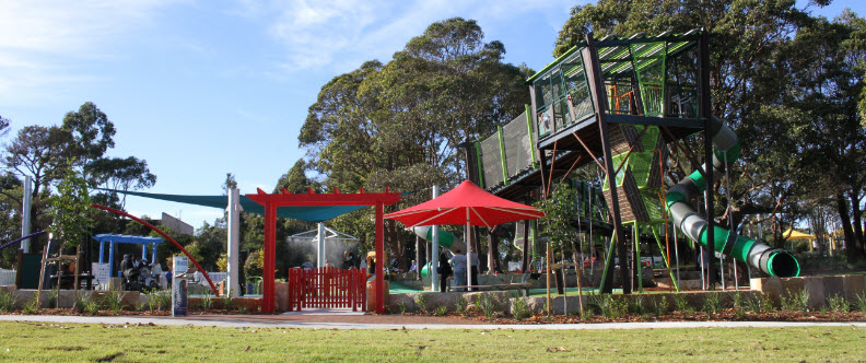 Red gate entry with tree house structure behind